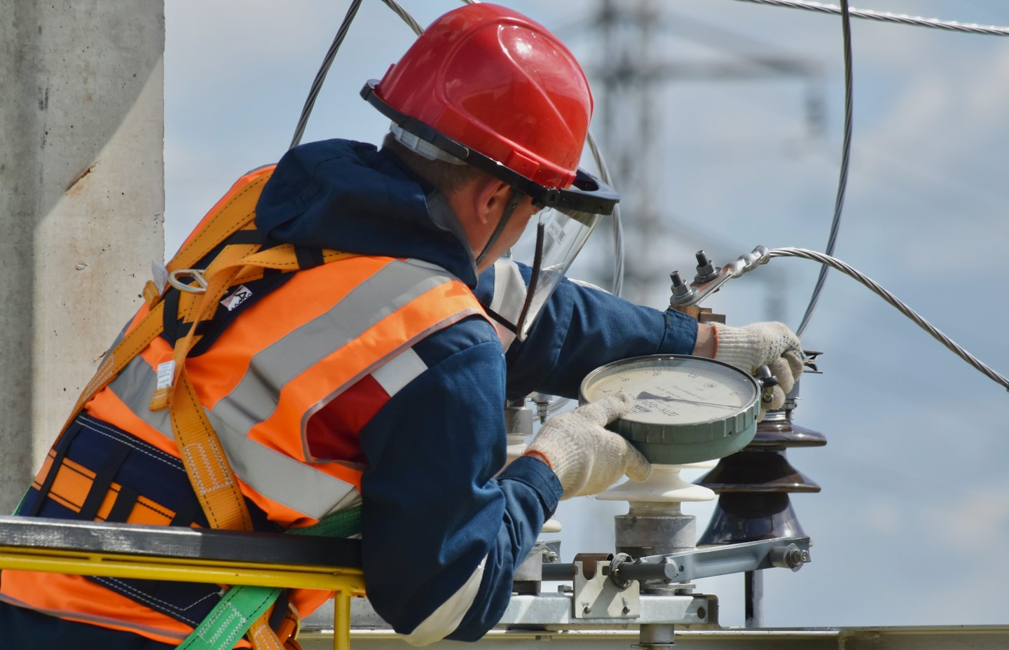 Technicus in veiligheidsvest stelt buiten elektrische apparatuur af.